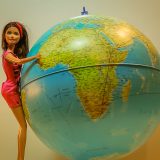 Barbie voyage devant un globe terrestre, choisir une agence pour le tour du monde