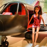 Barbie voyage assise sur un avion jouet, nos billets tour du monde sont réservés