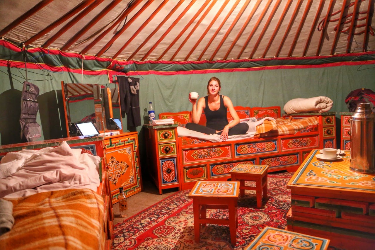 Intérieur de notre yourte : lits, poêle et mobilier mongol peint de couleurs vives