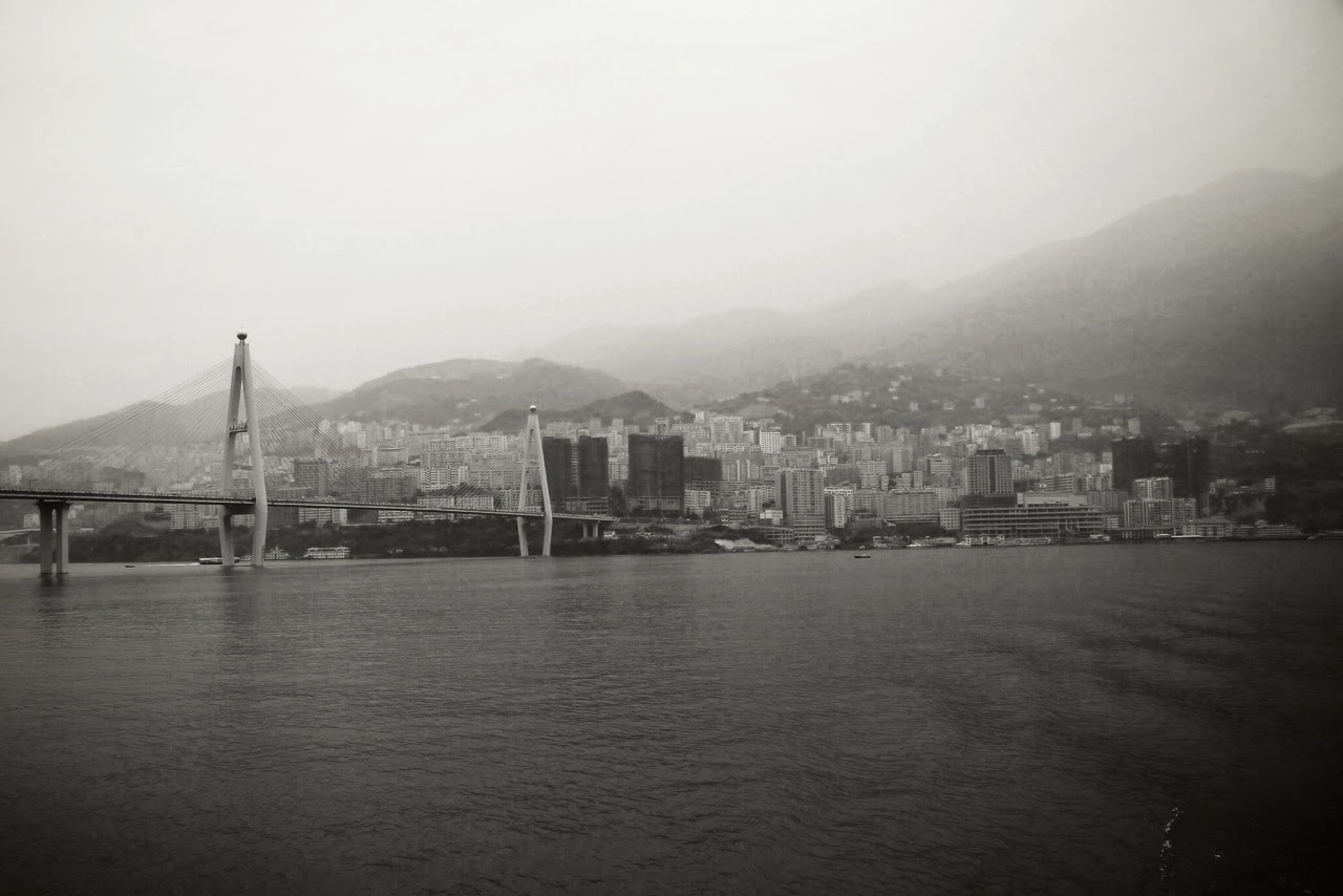 Ville et pont sur le fleuve dans la brume