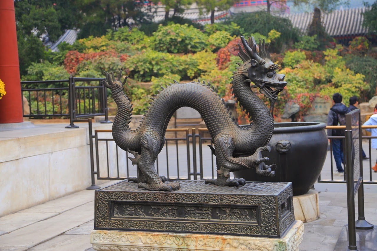 Dragon en bronze devant un pavillon