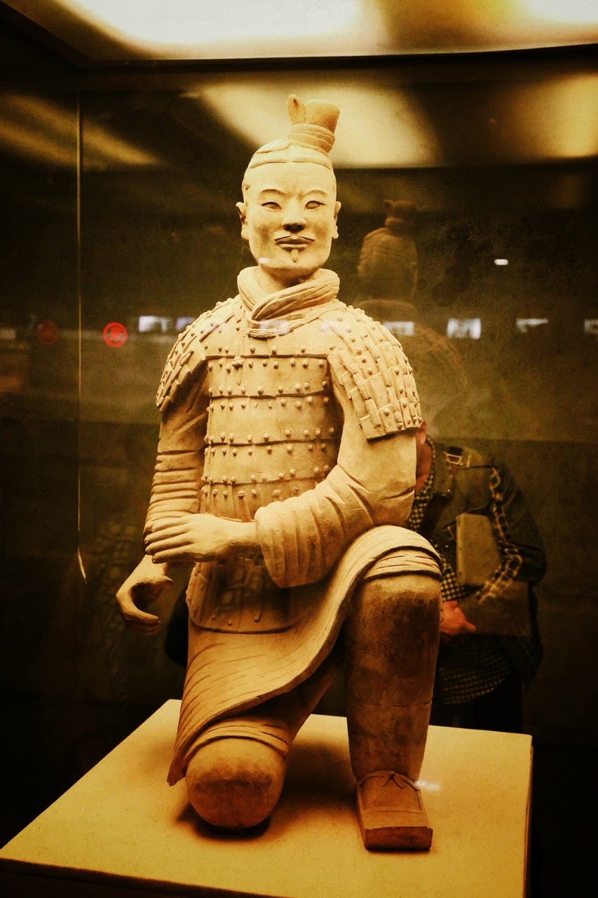 Archer agenouillé en terre cuite sous vitrine
