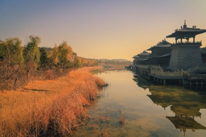 Pavillon chinois se reflétant dans un plan d’eau au soleil couchant