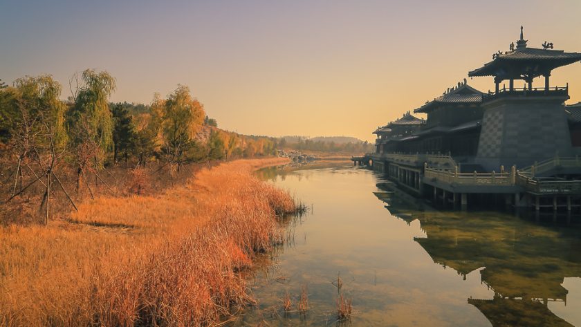Pavillon chinois se reflétant dans un plan d’eau au soleil couchant