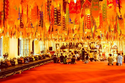 Fidèles réunis sous les guirlandes d'un temple de Chiang Mai