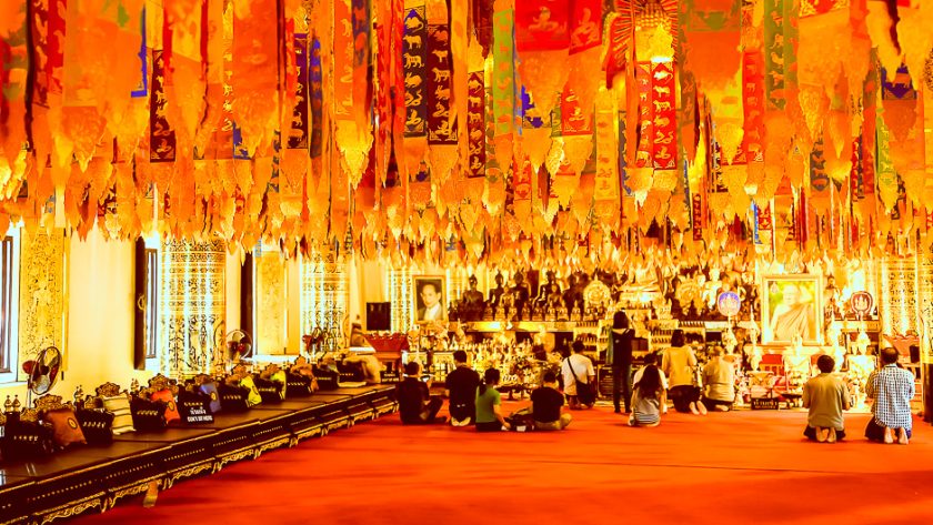 Fidèles réunis sous les guirlandes d'un temple de Chiang Mai