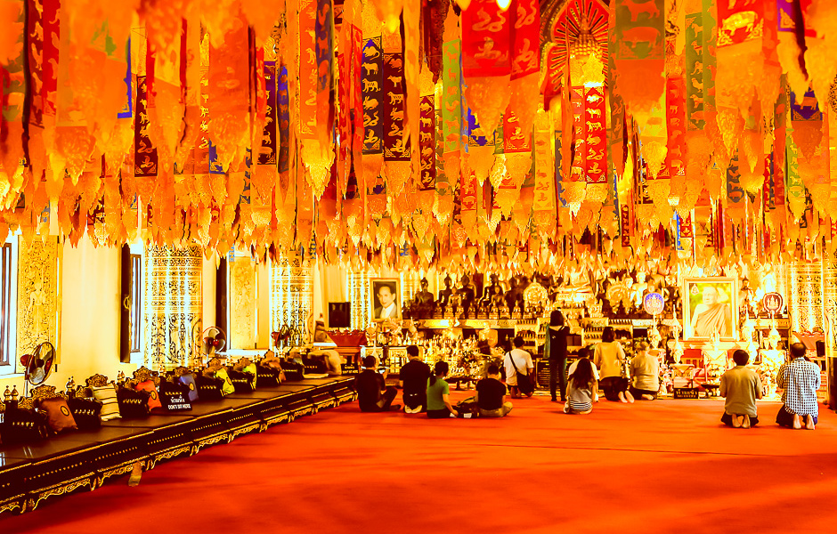 Fidèles réunis sous les guirlandes d'un temple de Chiang Mai