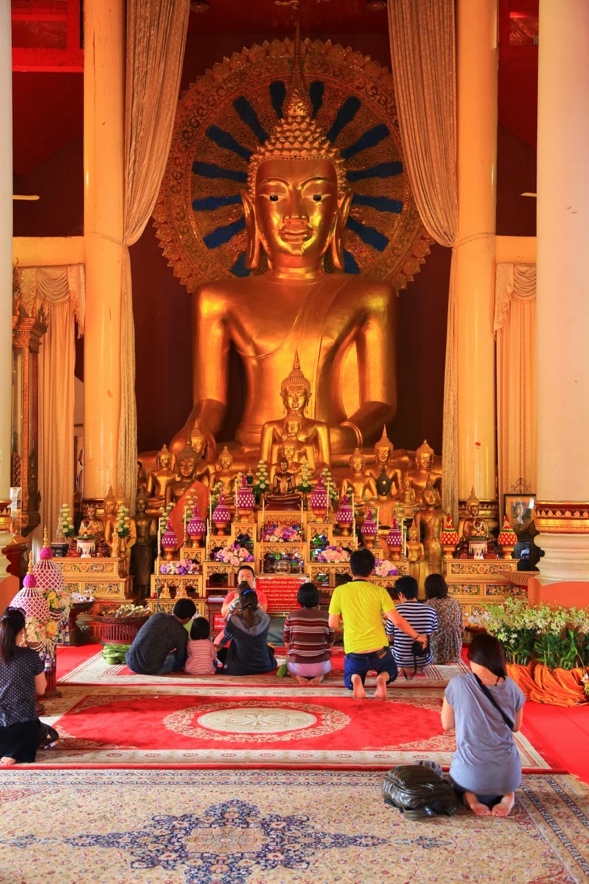 Bouddha doré entouré d'offrandes