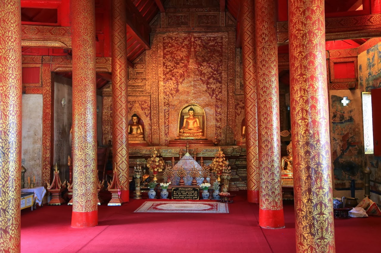 Bouddha dans un sanctuaire aux murs rouges