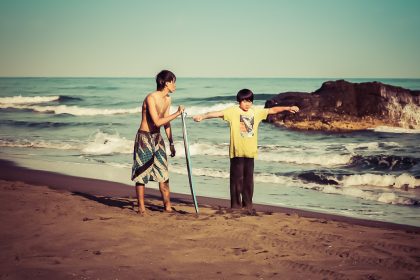 Surfeurs sur la plage de sable noir de Wai Ao, à Taiwan