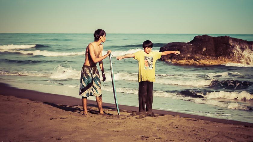 Surfeurs sur la plage de sable noir de Wai Ao, à Taiwan