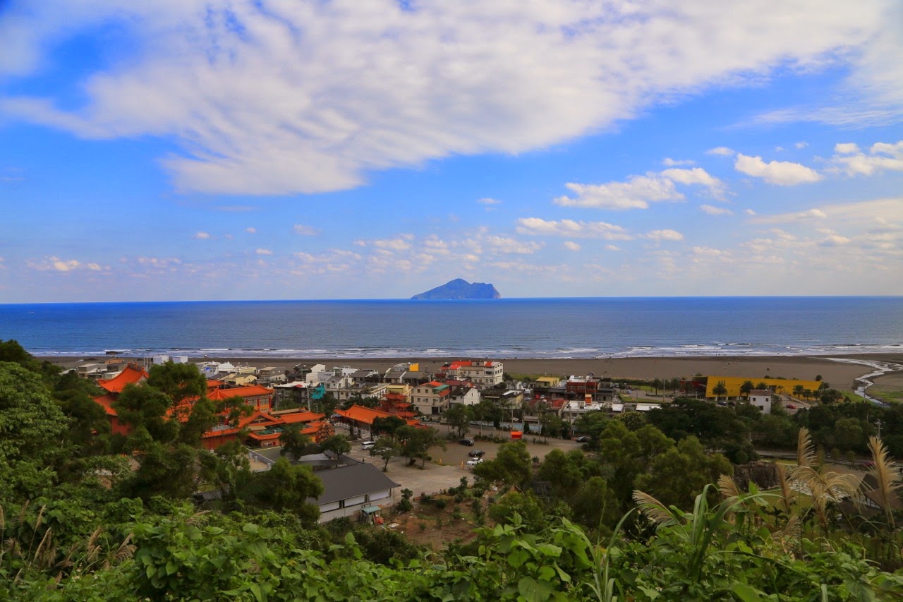 Village et île au large depuis les collines verdoyantes