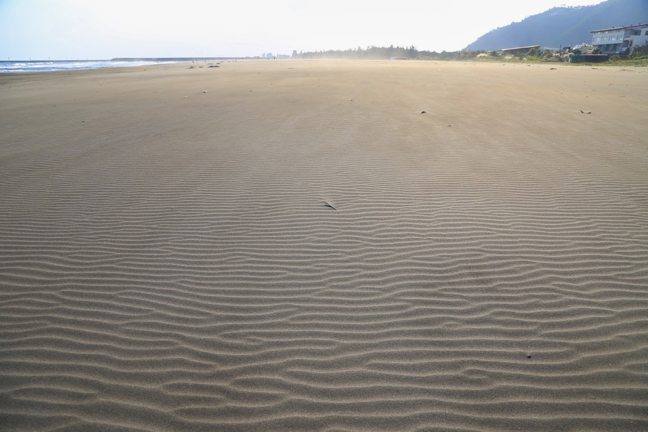 Plage de sable noir ridée par le vent