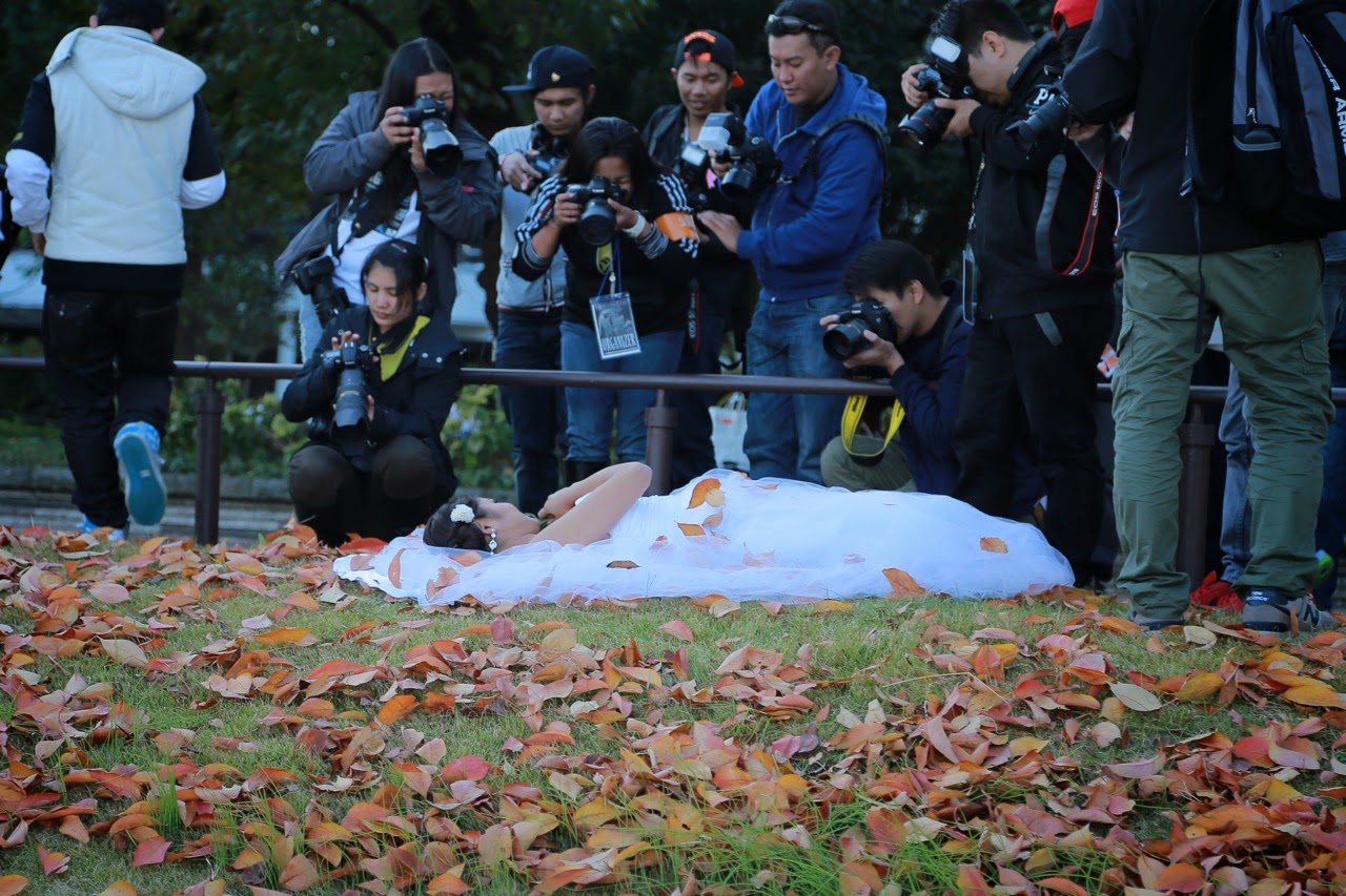 Séance photo d'une mariée allongée dans les feuilles mortes