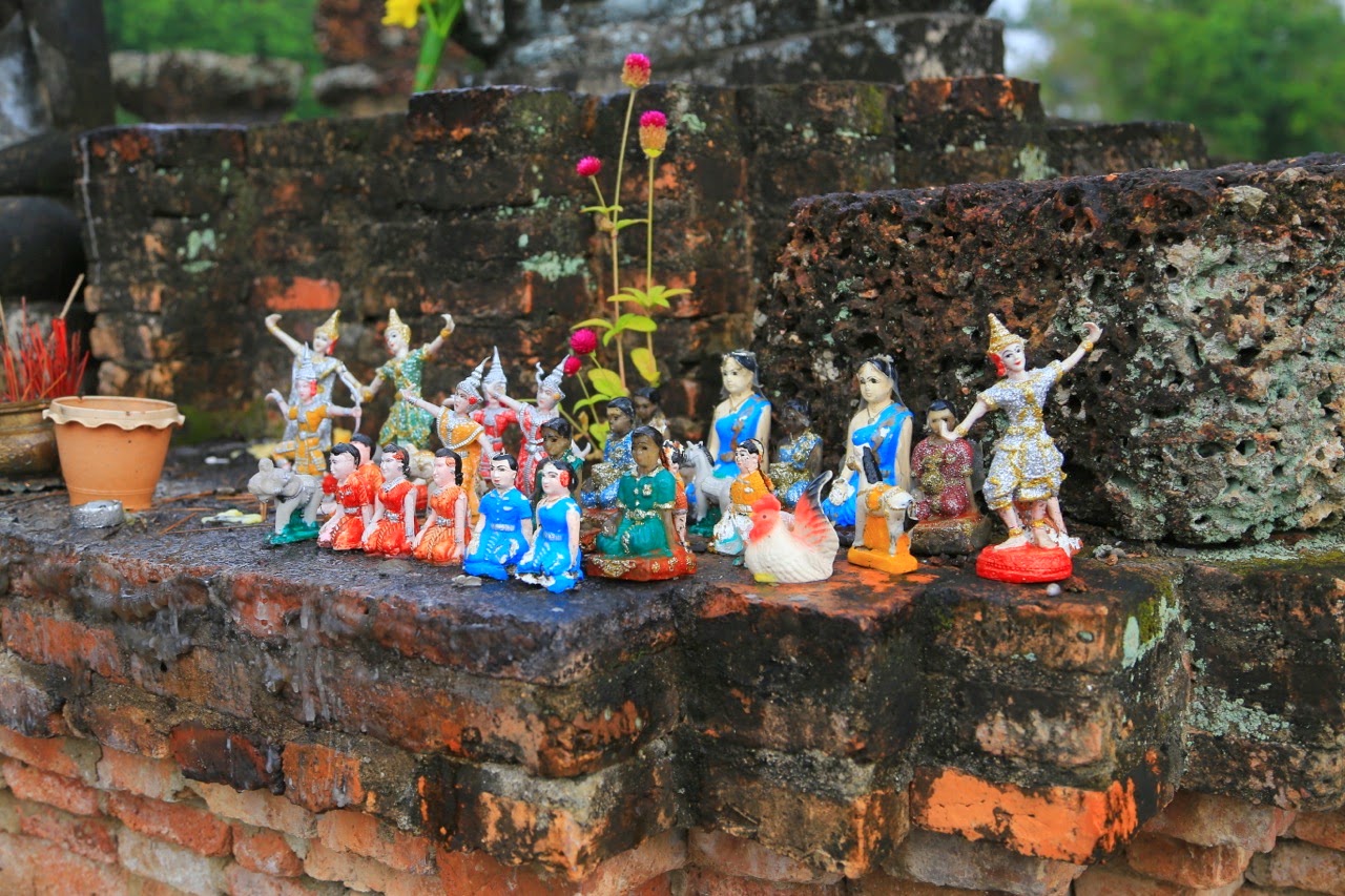 Figurines colorées déposées en offrande sur les ruines