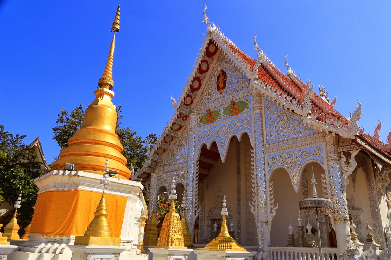 Chedi doré et temple décoré de mosaïque