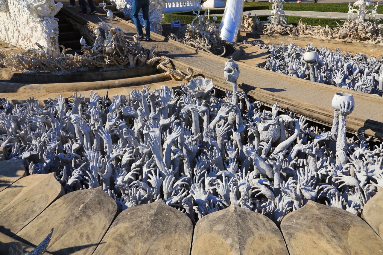 Bras tendus sculptés au pied du pont