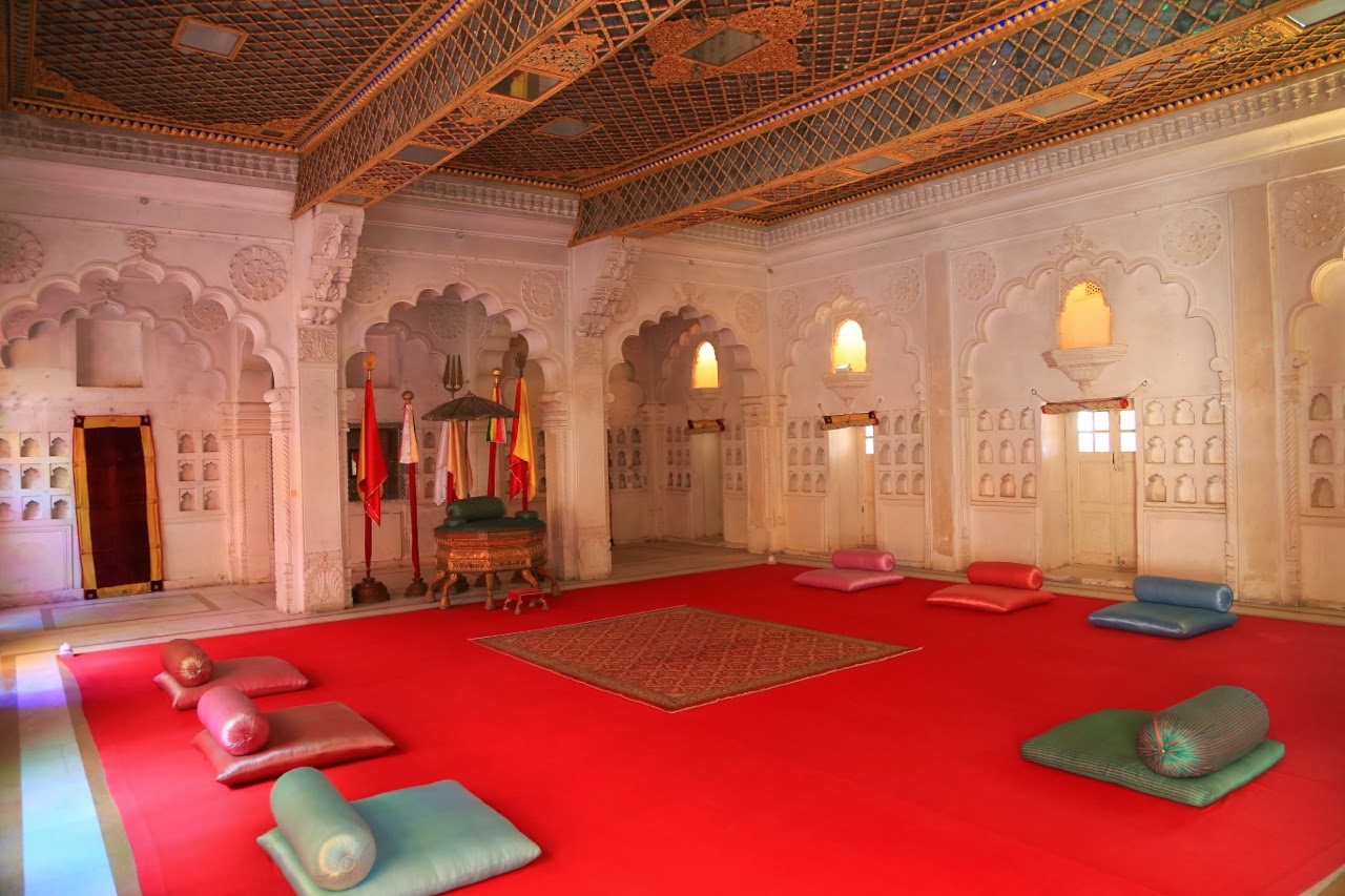 Salle aux tapis rouges et coussins