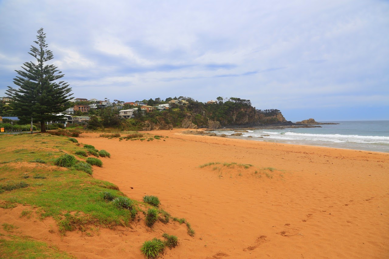 Plage de sable orangé sous un ciel gris