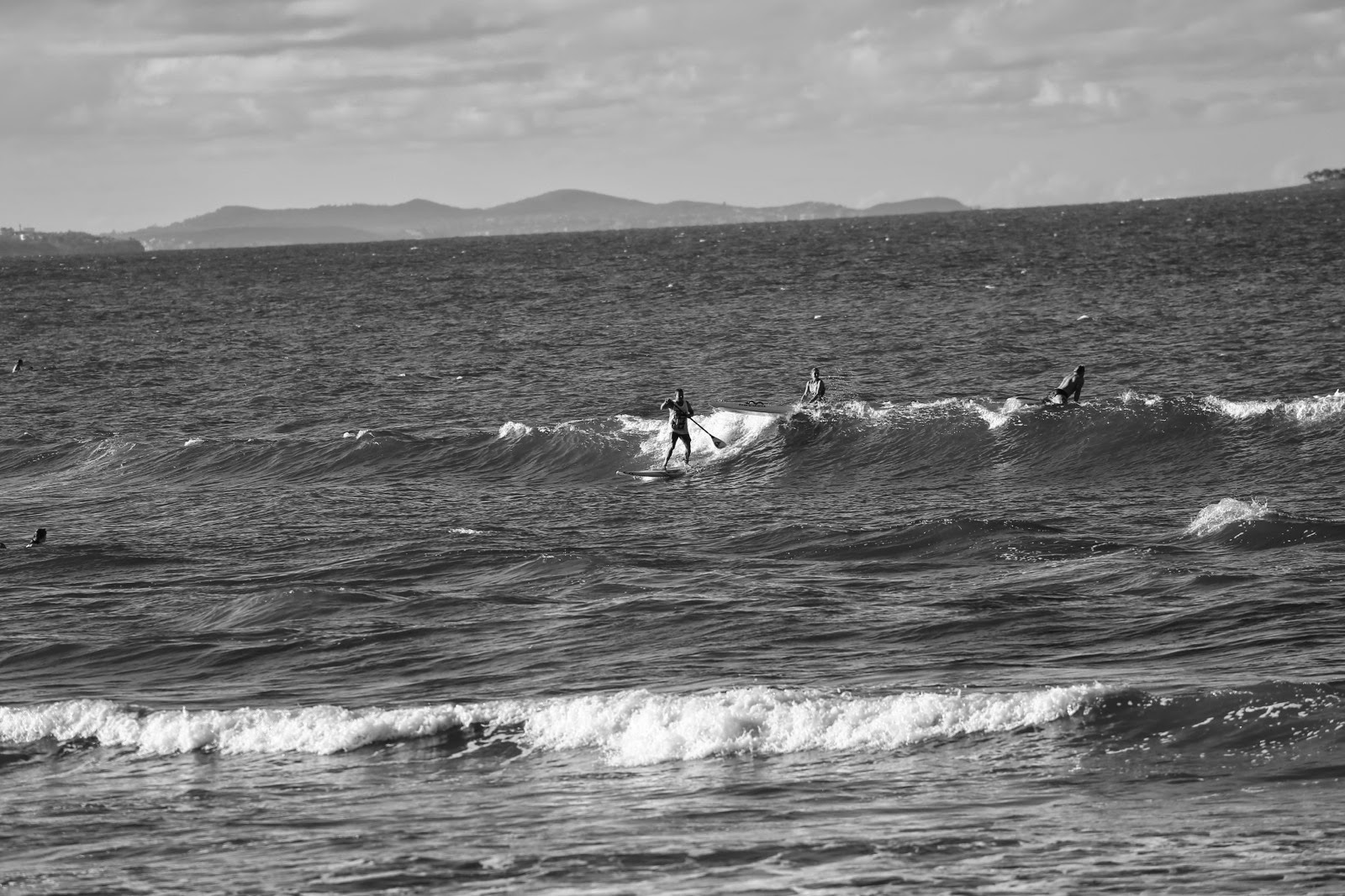 Surfeurs au large en noir et blanc