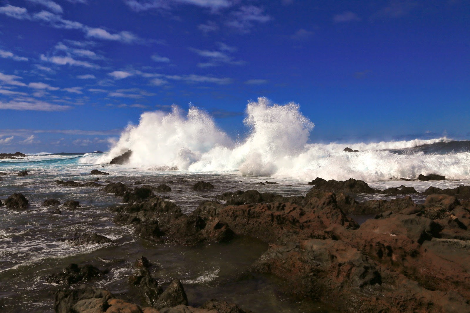 Rouleaux blancs contre la roche volcanique