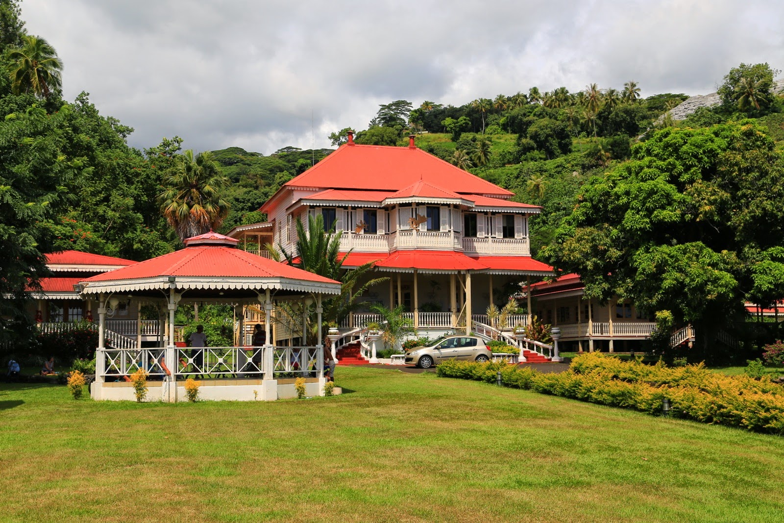 Maison coloniale au toit rouge dans un jardin tropical