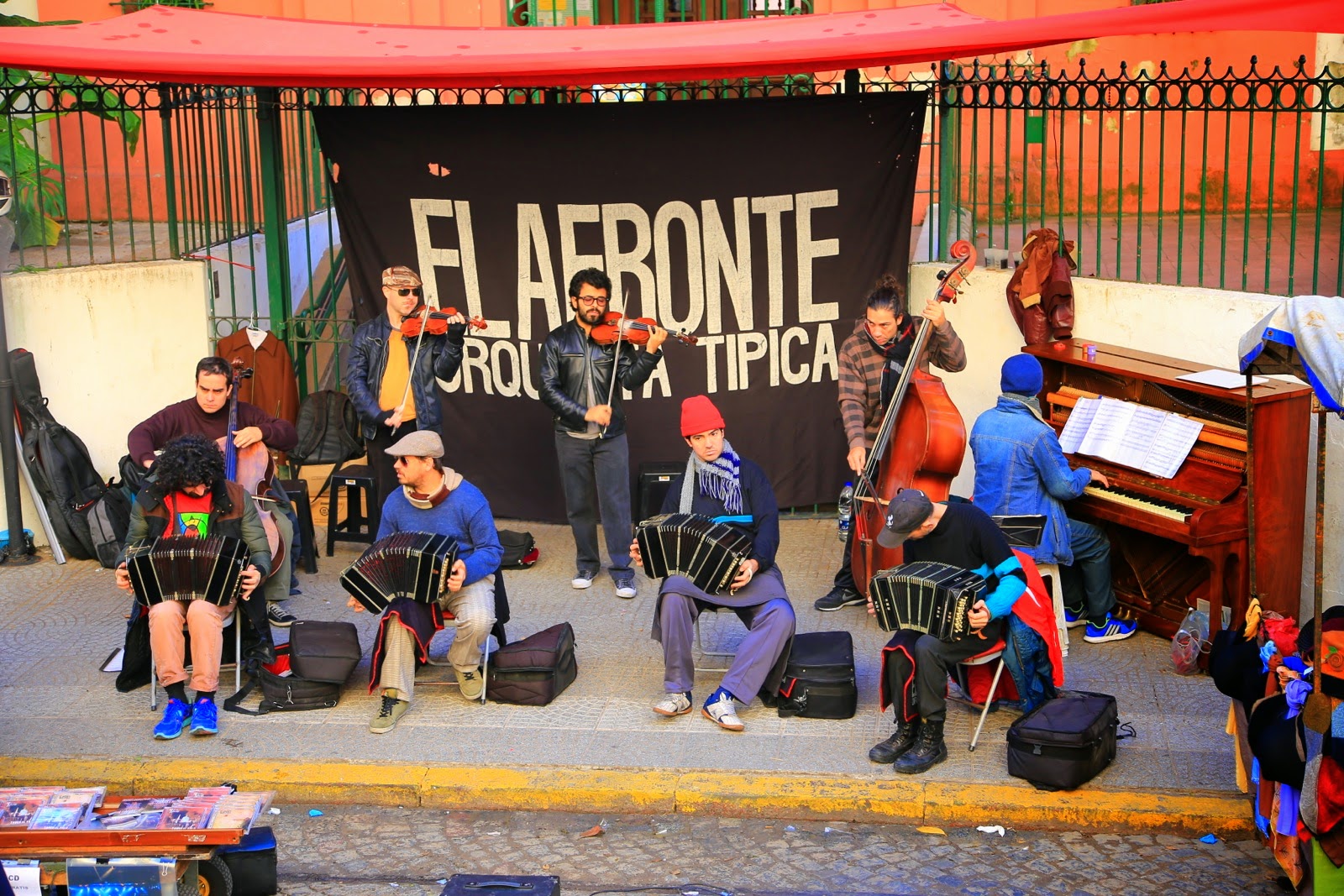 Groupe de musique devant une façade rouge