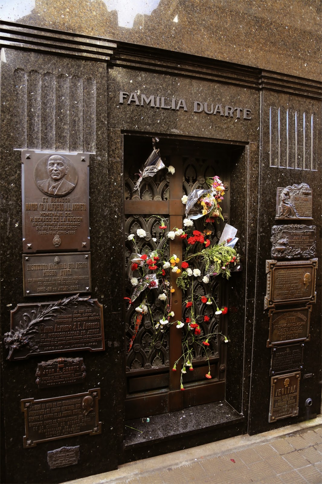 Plaques et fleurs sur un caveau de Recoleta