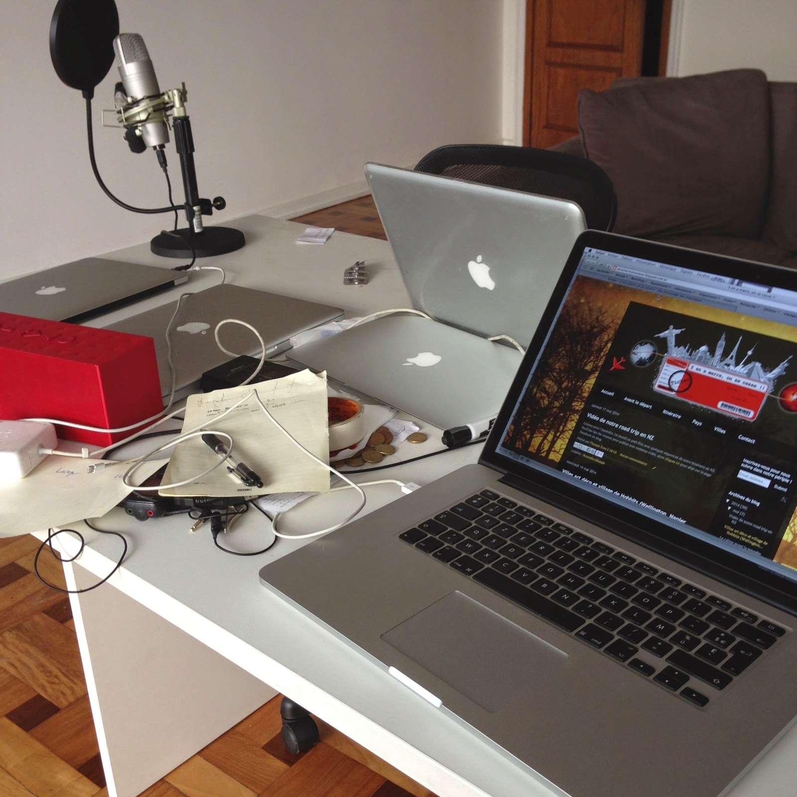 Table de la coloc encombrée de Macbook et de câbles