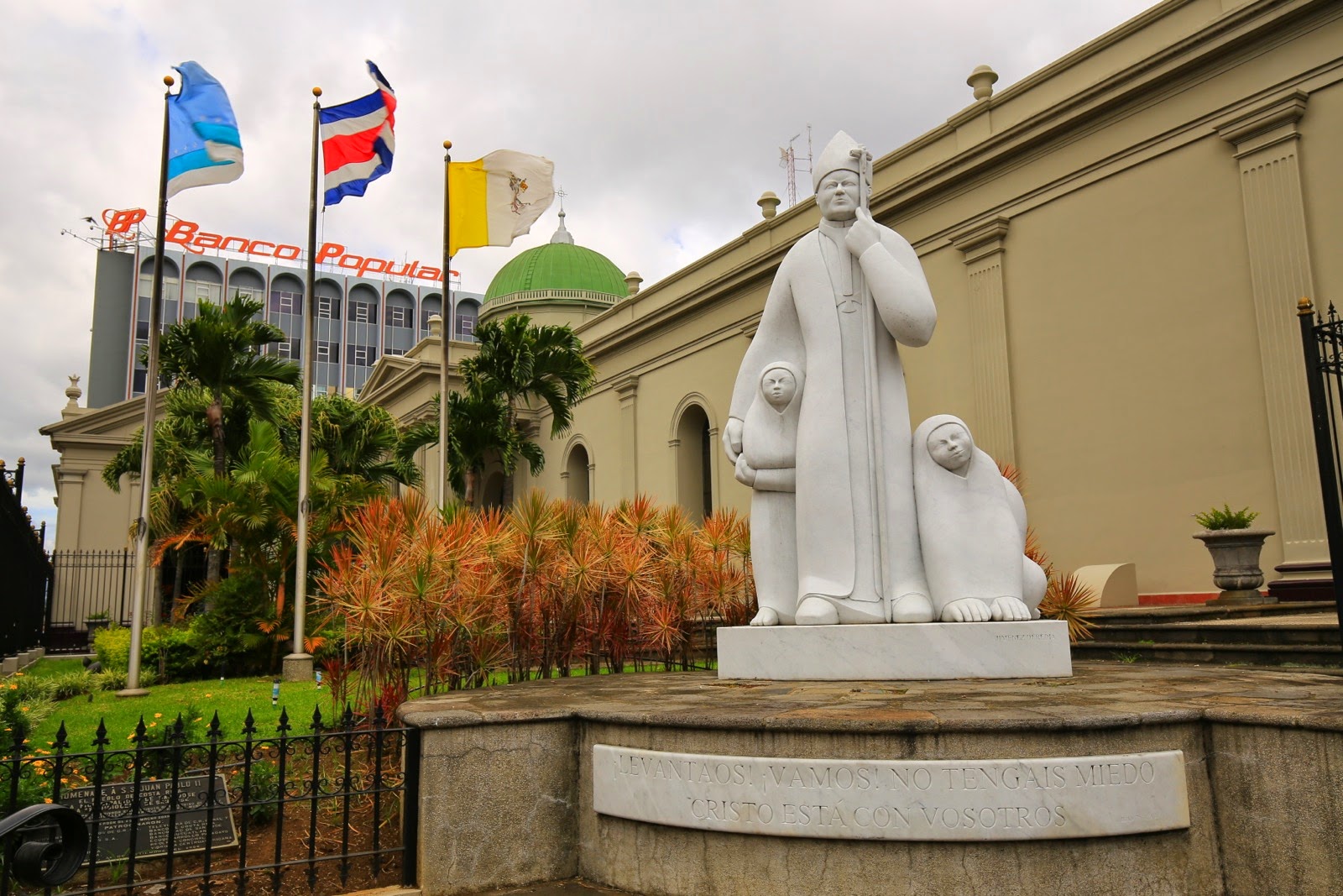 Statue blanche devant la cathédrale, sous les drapeaux