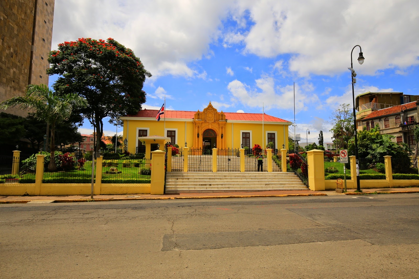 Une maison coloniale jaune et ses jardins