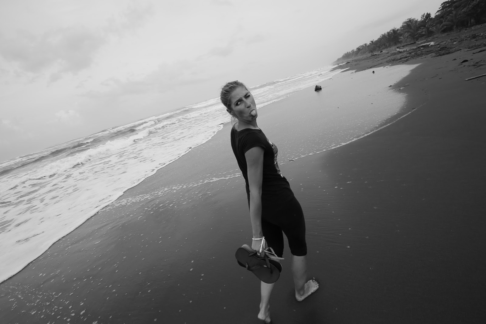 Une promeneuse sur la plage de sable noir de Tortuguero