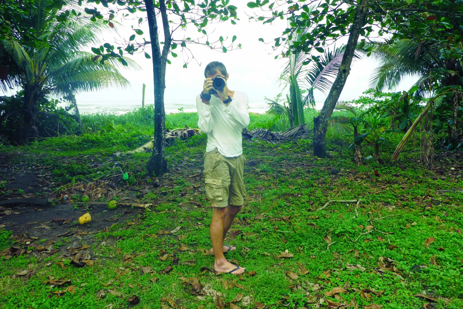 Un photographe pieds nus dans l’herbe détrempée