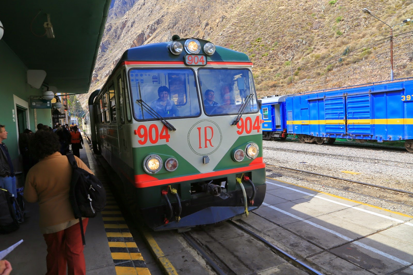 Train Inca Rail à quai, à côté d’un train bleu PeruRail