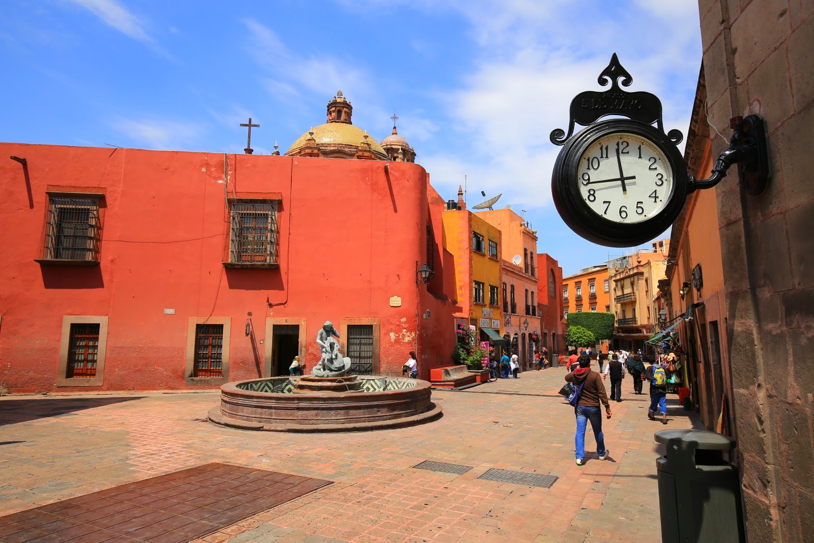 Place pavée, fontaine et horloge murale