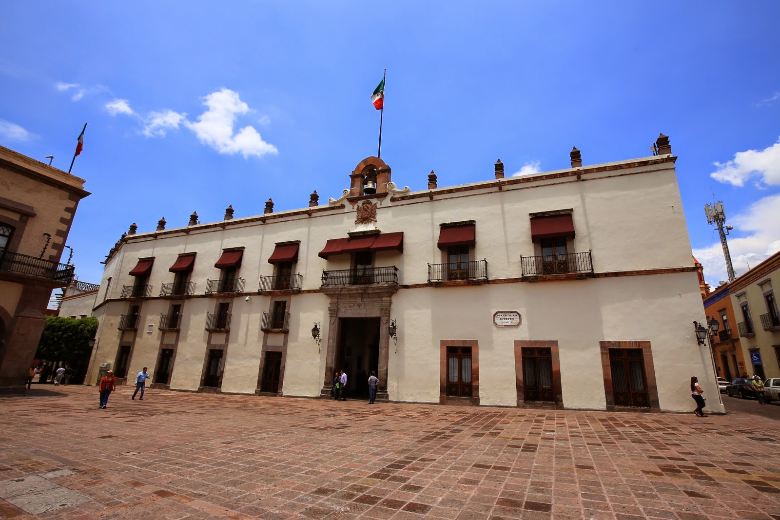 Palais blanc et drapeau mexicain sur une place