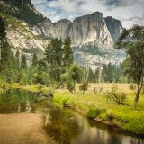 La vallée du Yosemite et ses falaises de granit, reflétées dans la Merced River