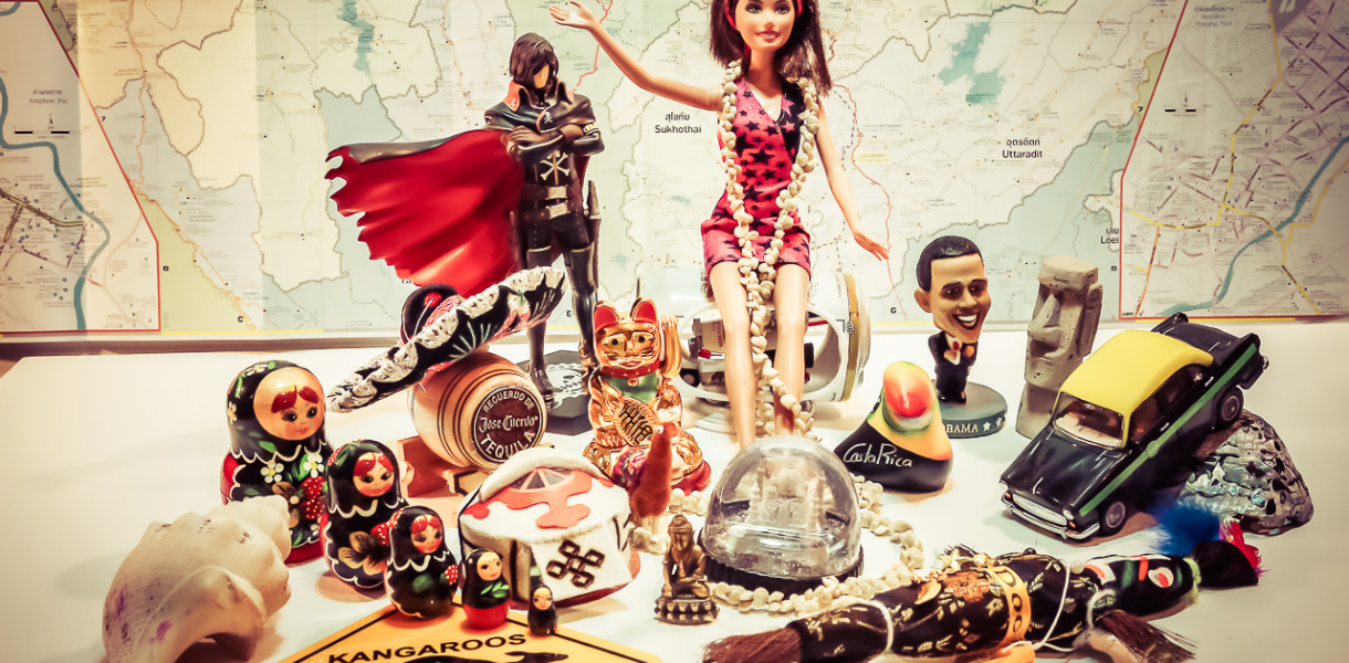 Souvenirs et figurines rapportés de notre tour du monde devant une carte du monde