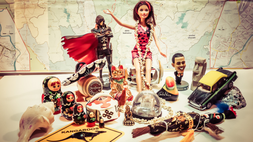 Souvenirs et figurines rapportés de notre tour du monde devant une carte du monde