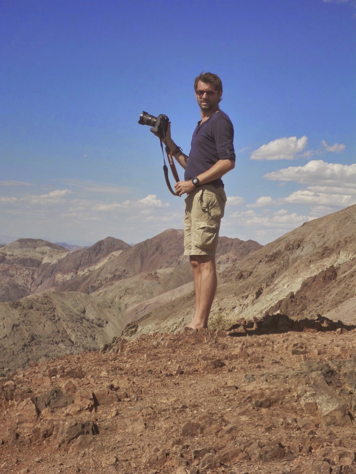 Photographe avec son trépied au sommet d’une colline désertique