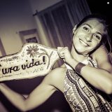 Une voyageuse brandit une pancarte « Pura vida ! »