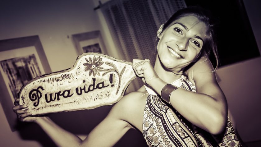 Une voyageuse brandit une pancarte « Pura vida ! »