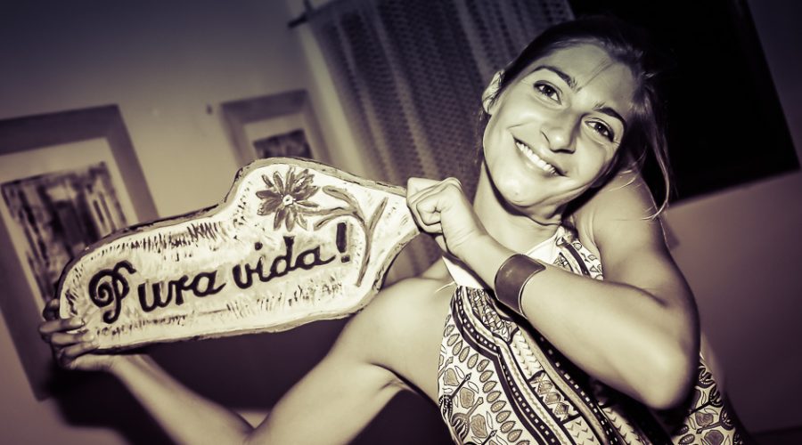 Une voyageuse brandit une pancarte « Pura vida ! »