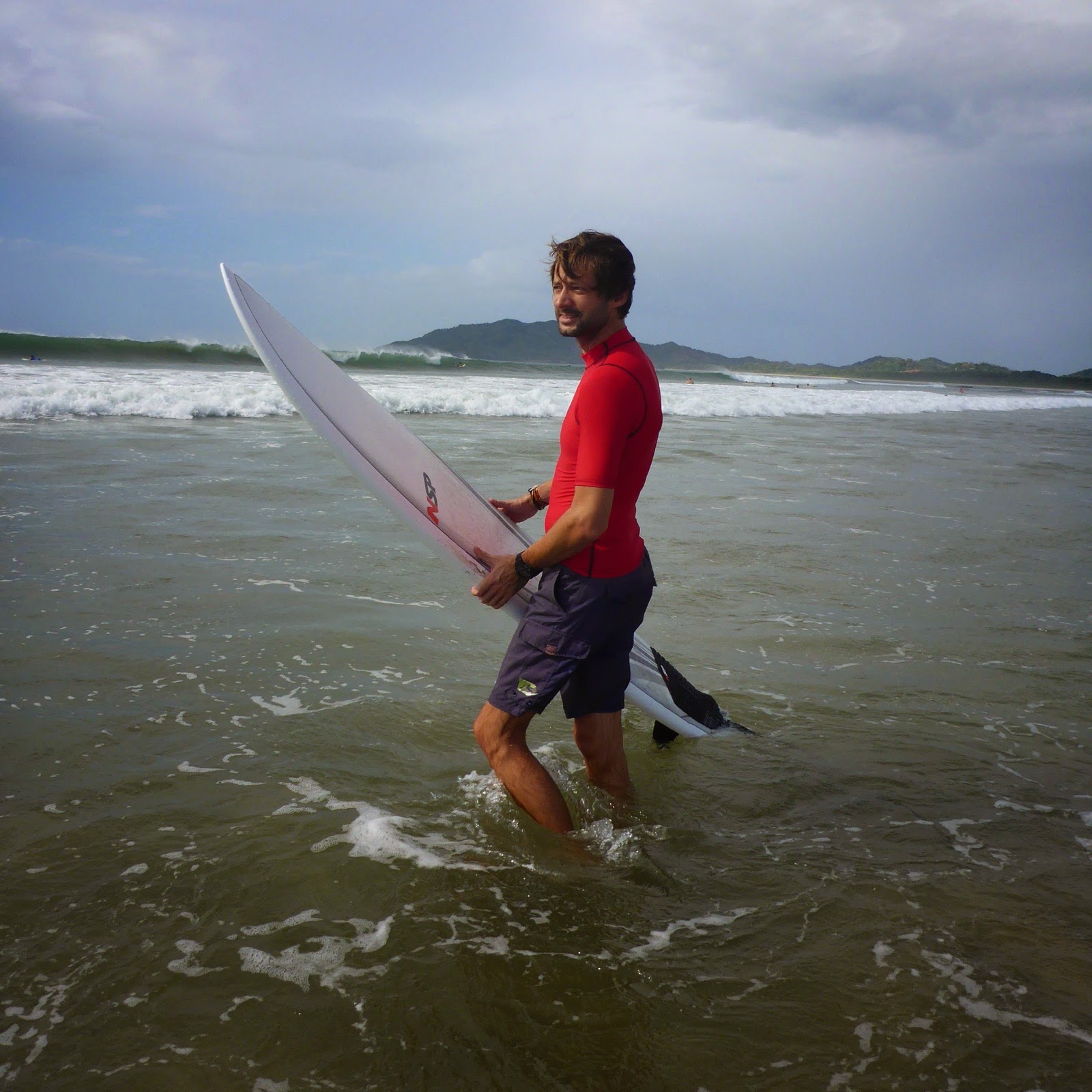 Un surfeur sort de l’eau, sa planche à la main