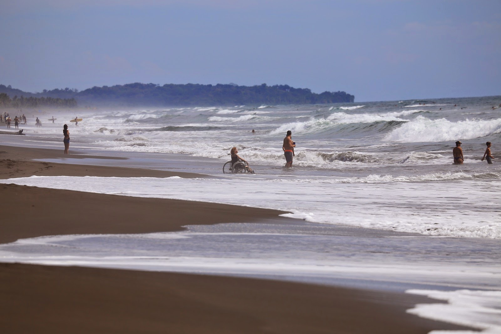 Surfeurs dans les rouleaux d’une large plage