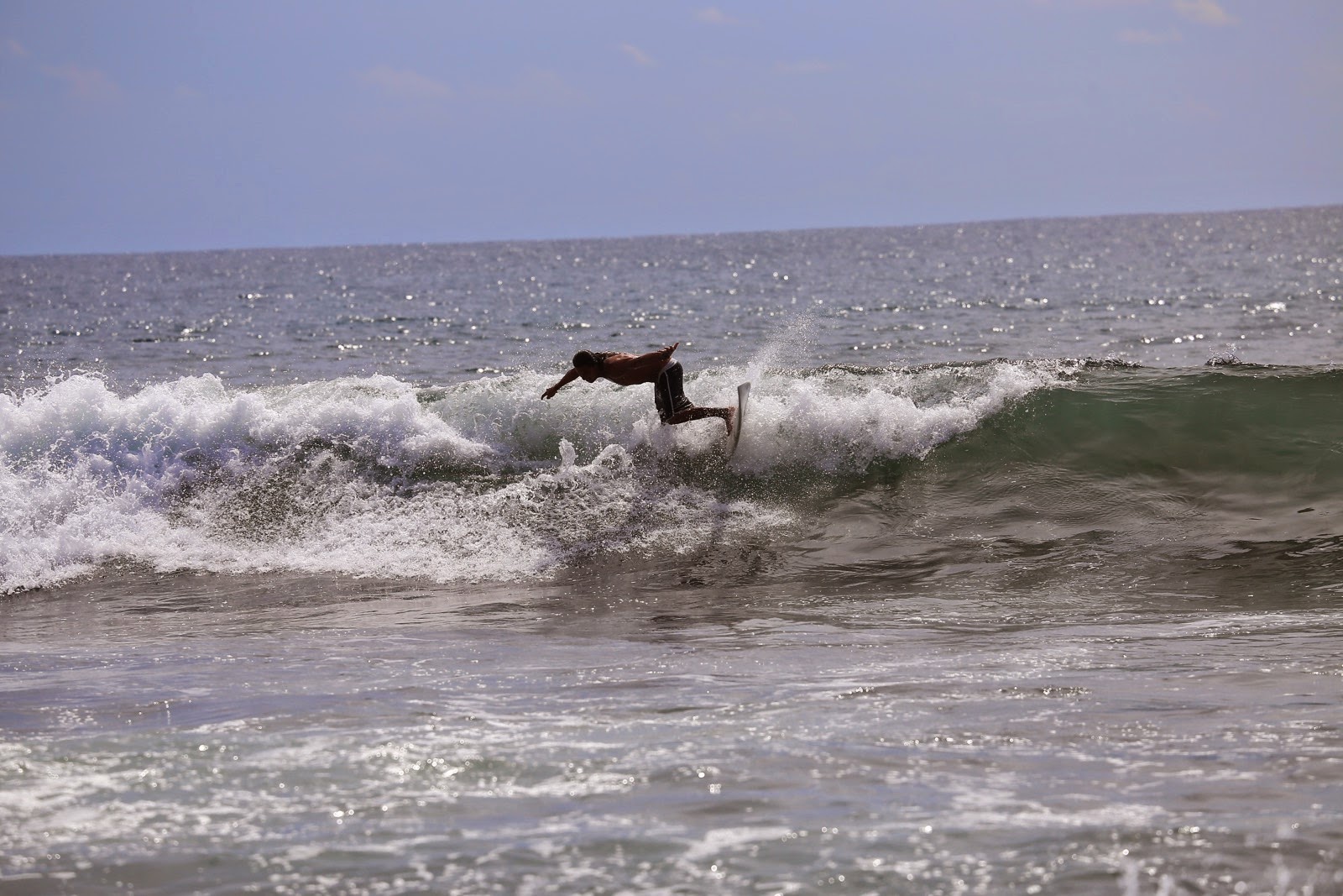 Un surfeur file sur la vague