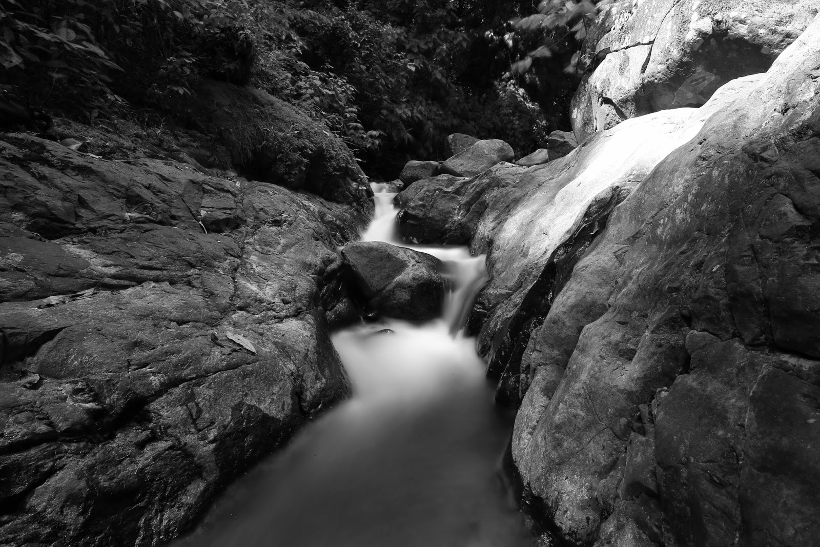 L’eau dévale les rochers polis, en noir et blanc