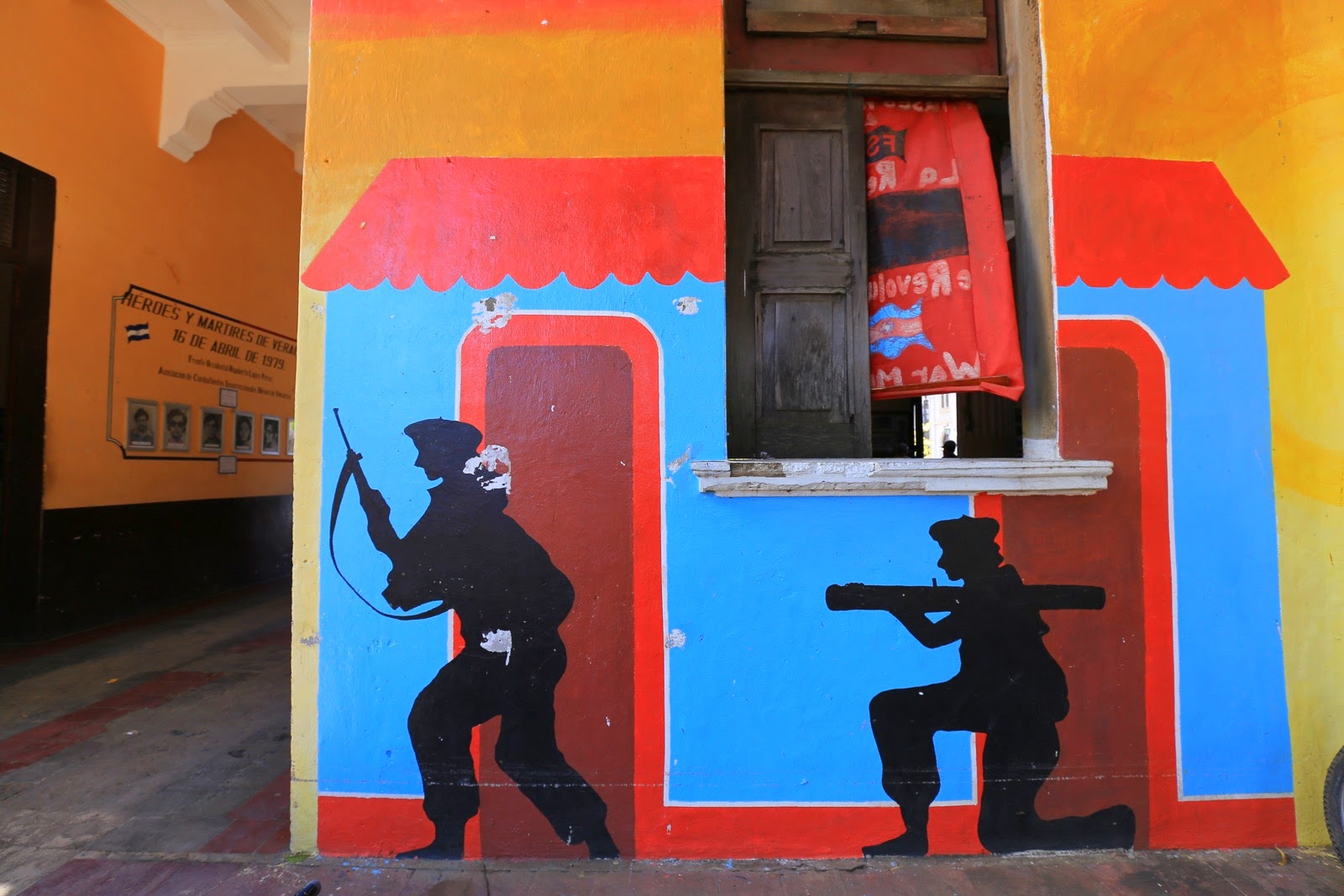 Silhouettes de combattants peintes sur un mur coloré