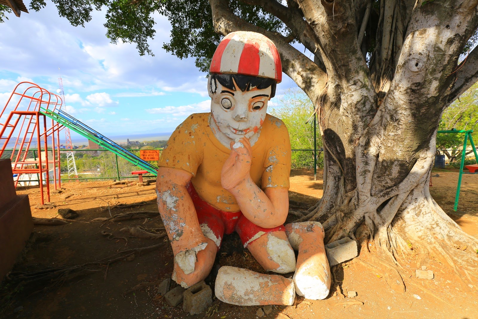 Statue d’enfant au pied d’un arbre