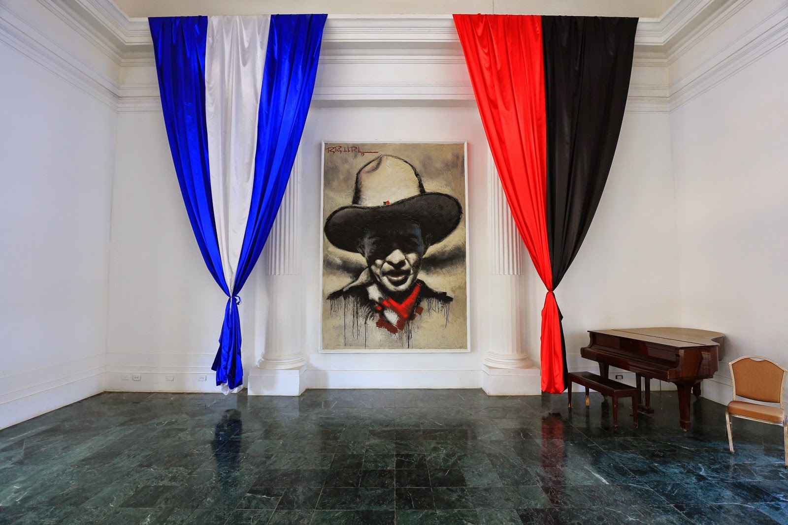 Portrait de Sandino entre des drapeaux bleu et rouge-noir